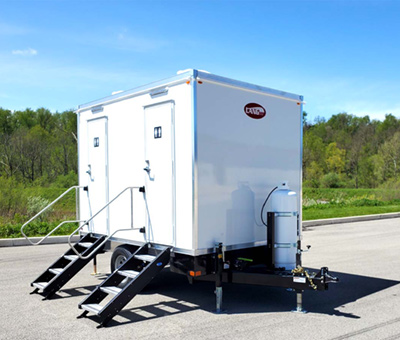 A side exterior view of a Lang 2 Station Eco Series Restroom trailer with a view of the attached propane tank.
